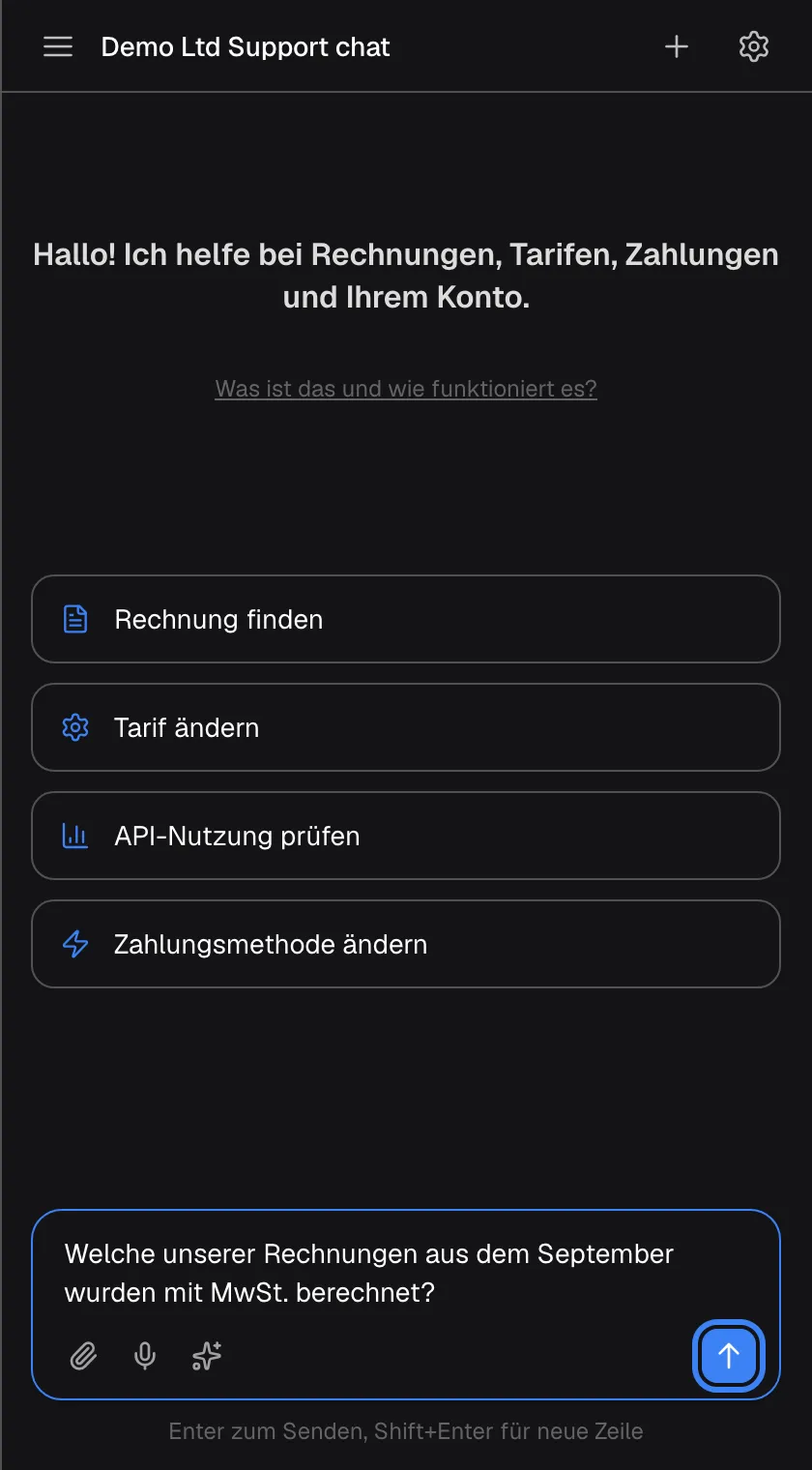 Der Startbildschirm mit einer Frage im Eingabefeld: „Welche unserer Rechnungen aus dem September wurden mit MwSt. berechnet?“. Die blaue Senden-Schaltfläche mit Pfeil nach oben rechts im Feld, beschriftet „Nachricht senden“, ist hervorgehoben und aktiv. Links liegen die Büroklammer für Anhänge, das Mikrofon für die Spracheingabe und das Funkel-Symbol für Prompt-Shortcuts. Auch Enter sendet; Shift+Enter beginnt eine neue Zeile.